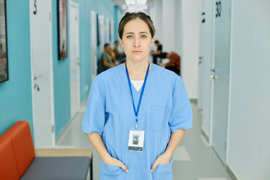 Nurse wearing scrubs standing in hospital corridor