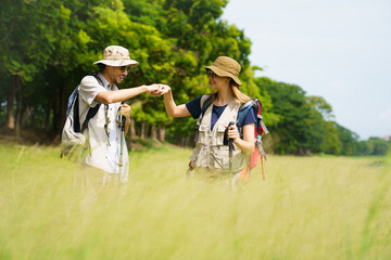 Man and woman are enjoy seeing a beautiful landscape and lake view while hiking.
