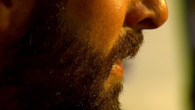 Close-up of a man's face with intense eyes and warm sunset light on his skin. beautiful caucasic european model with beard young male attractive