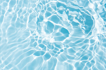 Blue water with ripples on the surface. Defocus blurred transparent blue colored clear calm water surface texture with splashes and bubbles. Water waves with shining pattern texture background.