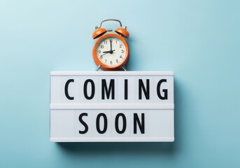 Retro alarm clock sits atop a coming soon announcement sign