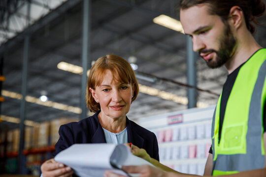 Manager and colleague examining checklist at warehouse