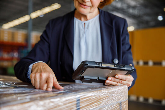 Manager with tablet PC examining in warehouse