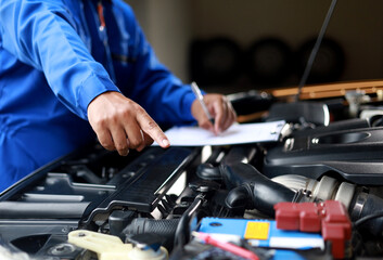 Check and inspect the condition of the car engine in detail. The mechanic is writing on a clipboard...