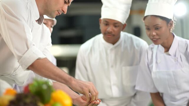Head chef leads a diverse team of assistants. The chef, dressed in a crisp white uniform in modern kitchen equipped at a high-end restaurant working during prep time, focused energy, teamwork.