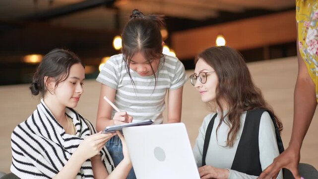 High school girls gather around laptops are taking special classes with specialized teachers with lessons that enhance skills for preparing for university entrance. enjoy time in inclusive learning.