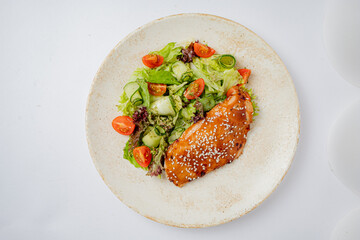 Grilled chicken served with a vibrant salad of tomatoes and cucumbers