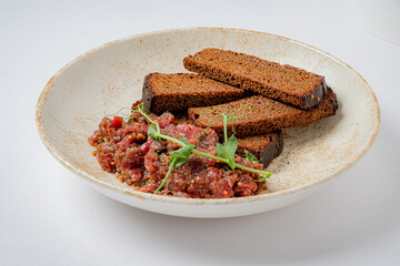 Beef tartare served with crispy dark rye bread and elegant garnishes