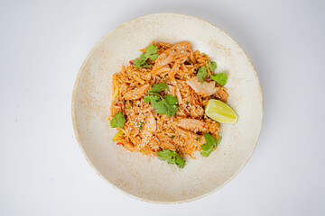 A colorful rice dish featuring tender chicken, fresh herbs, and a burst of citrus from lime