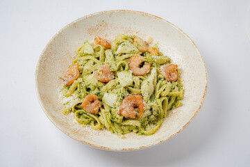 Savory pasta topped with shrimp and a rich pesto sauce, showcasing fresh herbs and cheese