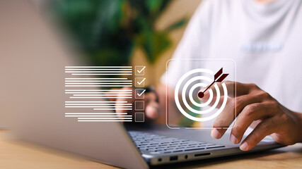 Businessman using virtual interface to set goals and manage checklist tasks on computer. Concept of productivity, planning, digital transformation, and workflow efficiency.