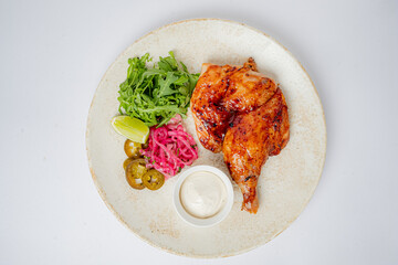 Grilled chicken leg with pickled onions, greens, and lime for a tasty meal