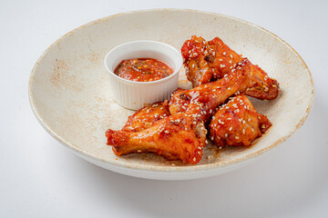 Honey sesame glazed chicken wings, garnished and served with a tasty dip