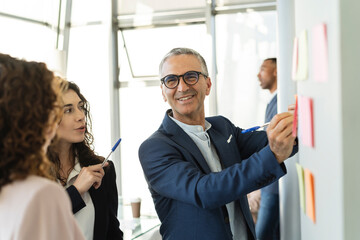 Smiling businessman preparing strategy with colleagues at office
