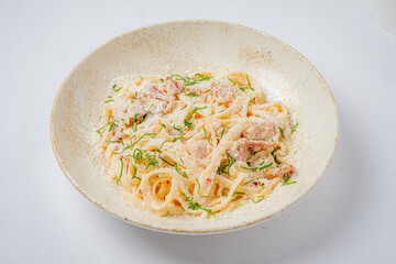 Fettuccine with creamy sauce and vibrant herbs is invitingly served in a rustic bowl