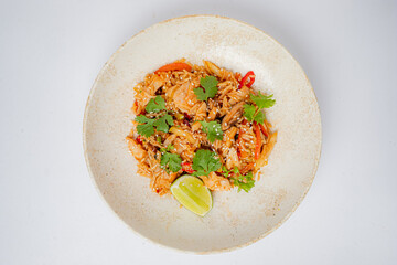 Shrimp fried rice topped with cilantro and lime on a rustic plate