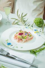 A gourmet pasta dish, adorned with edible flowers, in a serene dining setting