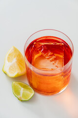 A refreshing cocktail with ice, garnished with fresh lemon and lime wedges. Enjoy!