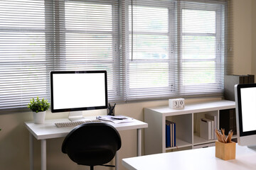Bright modern office with desktop computer, potted plant, and documents on a white desk