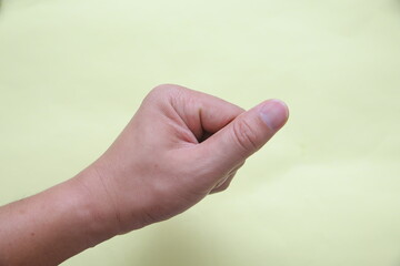 Close-up of a person clipping fingernails using a nail clipper on a light background.