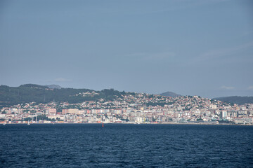 Coastal cityscape of Vigo captured from the center of the Vigo Estuary with a skyline of buildings and a clear sky