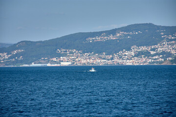 Coastal cityscape of Vigo captured from the center of the Vigo Estuary with a skyline of buildings and a clear sky