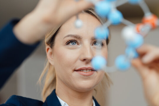 Smiling businesswoman examining molecular model in office