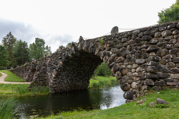 Historic Stone Arch Bridge Over Calm River in Serene Countryside Setting