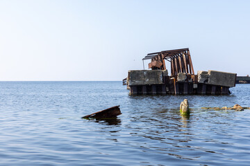 An old, ruined pier structure made of concrete and steel
