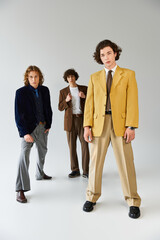 Young stylish friends showcase unique fashion choices in trendy studio setting during afternoon