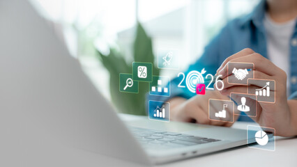 Businessman working on laptop with 2026 business strategy planning, digital marketing, financial data analytics, and growth goals. Future planning and KPI tracking concept.