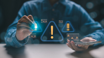 Close-up of a hand holding a smartphone with digital warning signs and error alerts on screen. Concept of cybersecurity threat, system warning, malware risk, and digital danger detection.