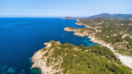 Fototapeta premium Vibrant summer Mediterranean seascape with a view from the sea, showcasing green cliffs, blue sky, and a rocky coastline