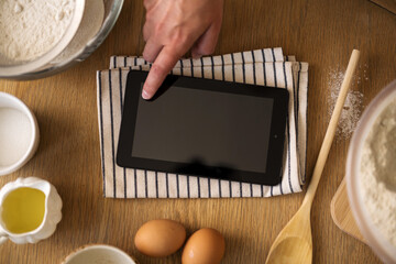 Using a digital tablet in the kitchen for cooking and finding a recipe