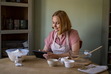Woman using a device to find an online recipe