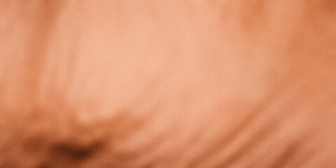 Fototapeta premium A close-up view of a textured, copper-colored surface. Shade from light to dark orange-brown, rose cold, brass, with a subtle variation in tones and modern, elegant surface background.