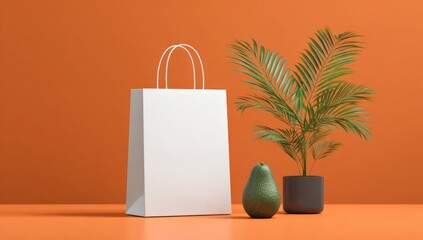 White shopping bag, avocado, and plant on orange background