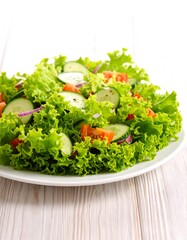 Fresh salad with lettuce, cucumber, tomato, and onion