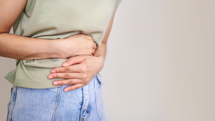 Young woman put her hand on her stomach because she had a very bad stomachache. menstrual pain,...