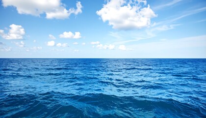 Obraz premium Calm ocean surface with blue water and a partly cloudy sky