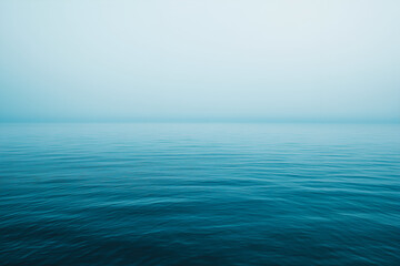 Obraz premium Serene Seascape with Calm Water on a Foggy Morning.