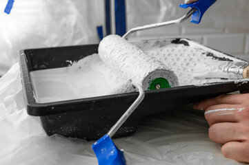 Paint roller dipped in white paint isolated closeup