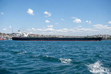 Large Cargo Ship Navigating the Bosphorus Strait Under a Clear Blue Sky in Daytime