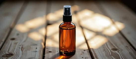 Fototapete Krankenhaus Glass spray bottle with amber liquid on a wooden surface.  © Cherrin
