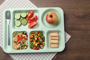 Plastic tray with tasty food and fork on wooden table, top view. School lunch
