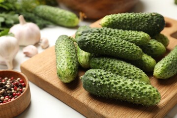 Making pickles. Fresh cucumbers and peppercorns on white table, closeup