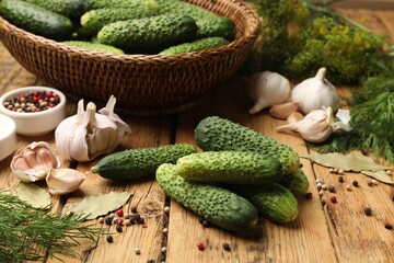 Making pickles. Fresh cucumbers and other ingredients on wooden table, closeup