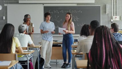 Team of teenager Spanish Students presenting group science project to classmates and teacher in High School in Spain - Powered by Adobe