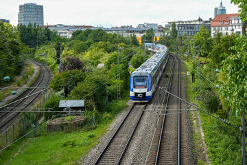 A blue and white Bayerische Regiobahn (BRB) train on its journey in the Sendling district. The BRB...