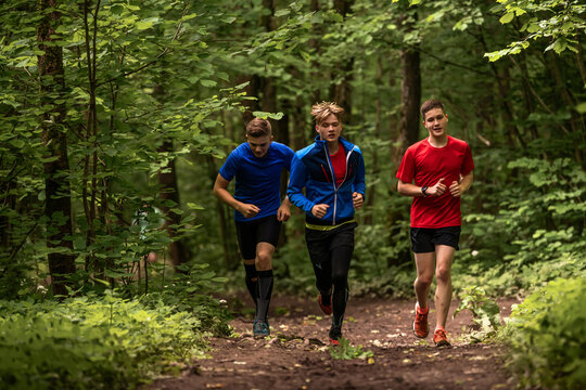 Three young boys running on a trail in a park